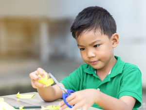 boy focusing on cutting skills