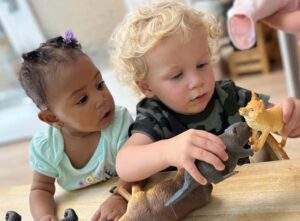 toddlers playing with toy animals