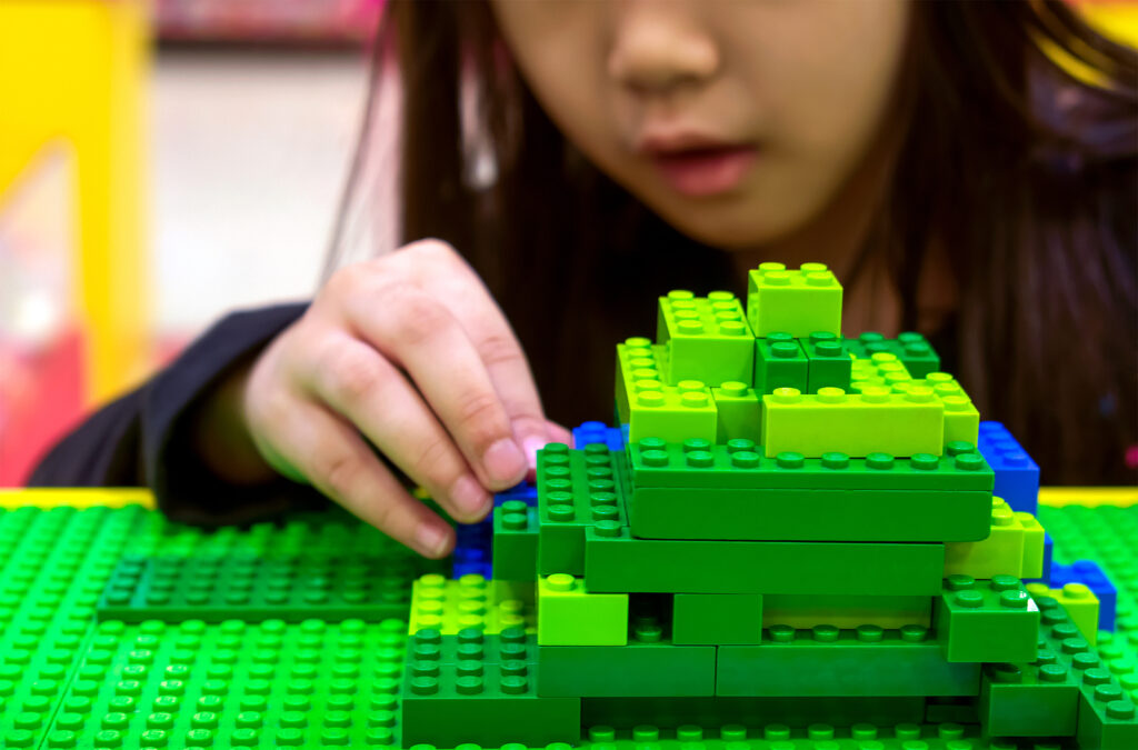 Asian girl playing with Minecraft Lego set