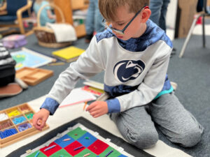 student working on Montessori checkerboard